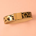 Leopard print bracelet with polished gold tone edging and rectangular magnetic clasp.