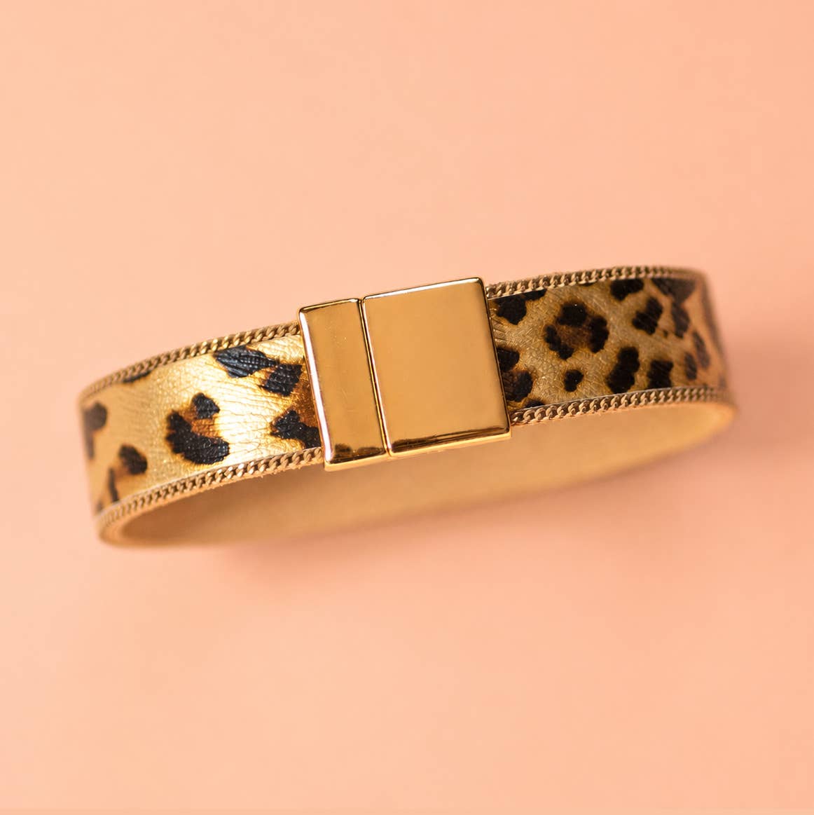 Leopard print bracelet with polished gold tone edging and rectangular magnetic clasp.