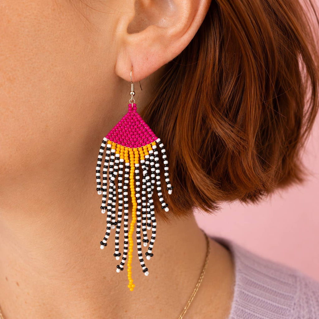 Pink and yellow beaded fringe statement earring worn on the ear.