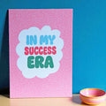 Colourful In My Success Era A5 print with blue, pink and green lettering on a bright pink patterned background.