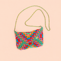 One of a kind multicolour envelope style crochet bag handmade by Corrine with green edging, long strap and red button.