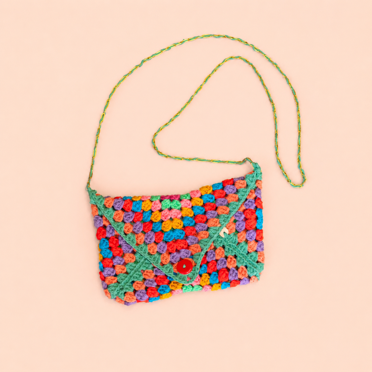One of a kind multicolour envelope style crochet bag handmade by Corrine with green edging, long strap and red button.