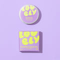 Blueberry Cheesecake Lip Balm 10g tin and purple gift box on a lilac background.