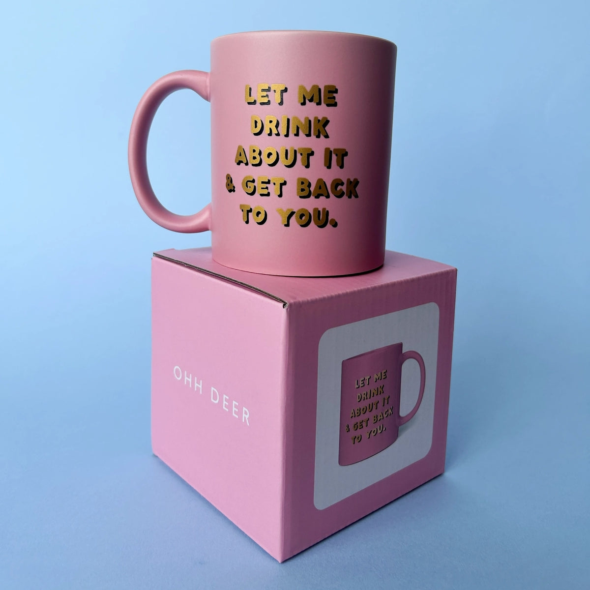 Pink Ohh Deer Let Me Drink About It ceramic mug displayed on its matching pink gift box.