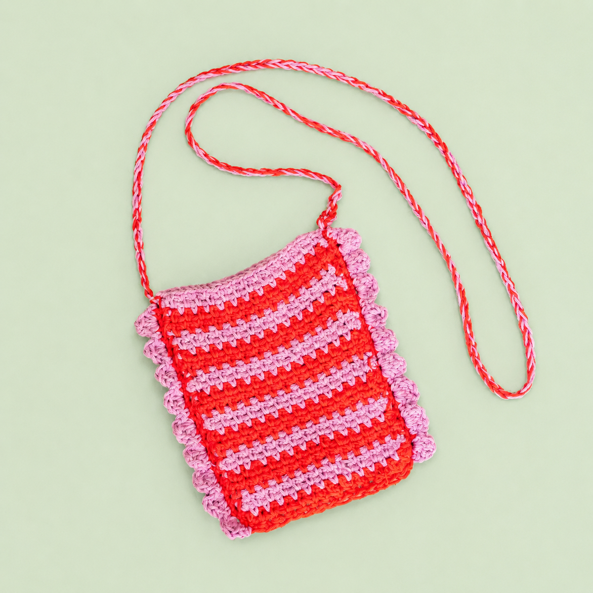One of a kind lilac and red striped crochet crossbody bag handmade by Corrine with scalloped edging and long strap.