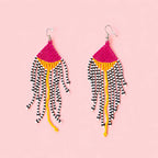 Pink and yellow beaded statement earrings with long black and white striped fringe.