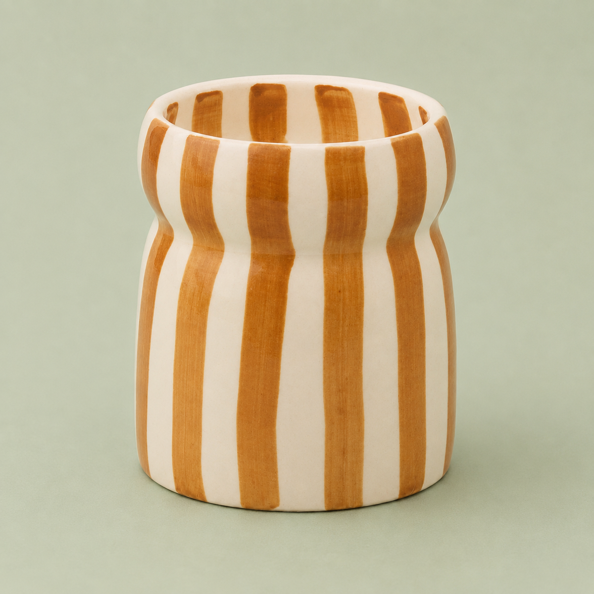 Hand painted caramel and cream striped Sienna Sunset ceramic candle with distinctive pinched shape.