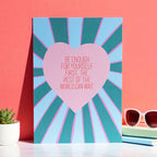 Uplifting A5 print with a large pink heart, positive self worth quote and teal and pale blue rays against a coral backdrop.