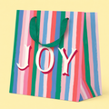 Small colourful striped gift bag with pink, green, blue and coral stripes, green handles and large JOY lettering.