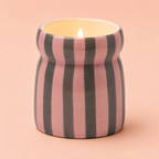 Lit Cinnamon and Clove candle in a hand painted pink and deep green striped ceramic vessel.