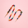 Multicolour chunky link glasses chain and necklace with red, blue, green, orange and gold tone links on a pale pink