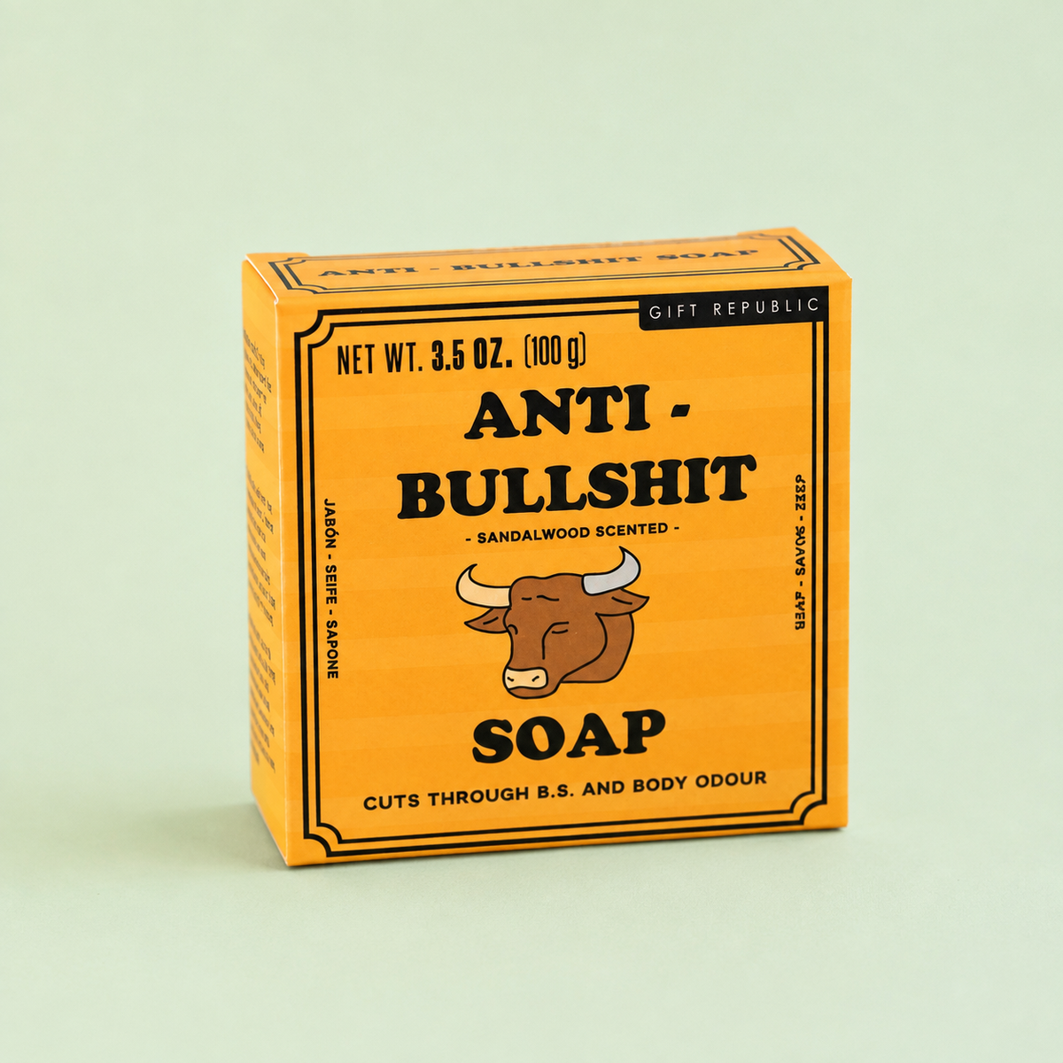 Box of 100g Anti Bullshit sandalwood scented soap in bright orange packaging with bull illustration on a pale green background.