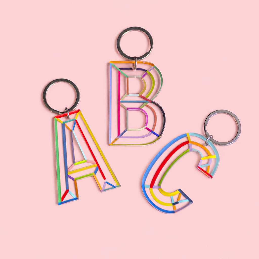 Colourful acrylic initial keychains in letters A, B and C with multicoloured line details and silver-tone rings.