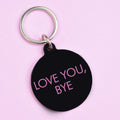 Black keychain with 'LOVE YOU, BYE' text on a pink background