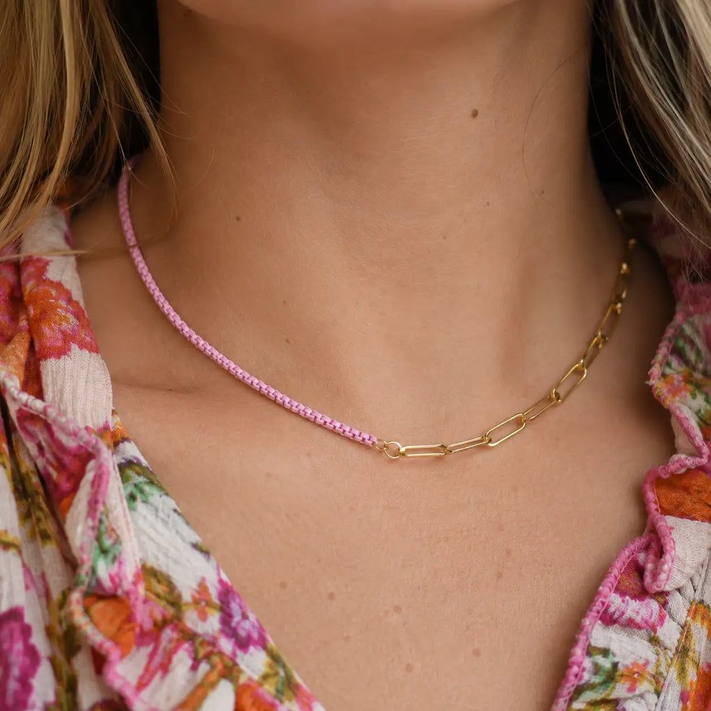 Two tone pale pink and gold plated chain necklace worn with a colourful floral top.