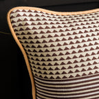 Reverse of cotton cushion featuring brown geometric and striped patterns with contrasting peach piping.