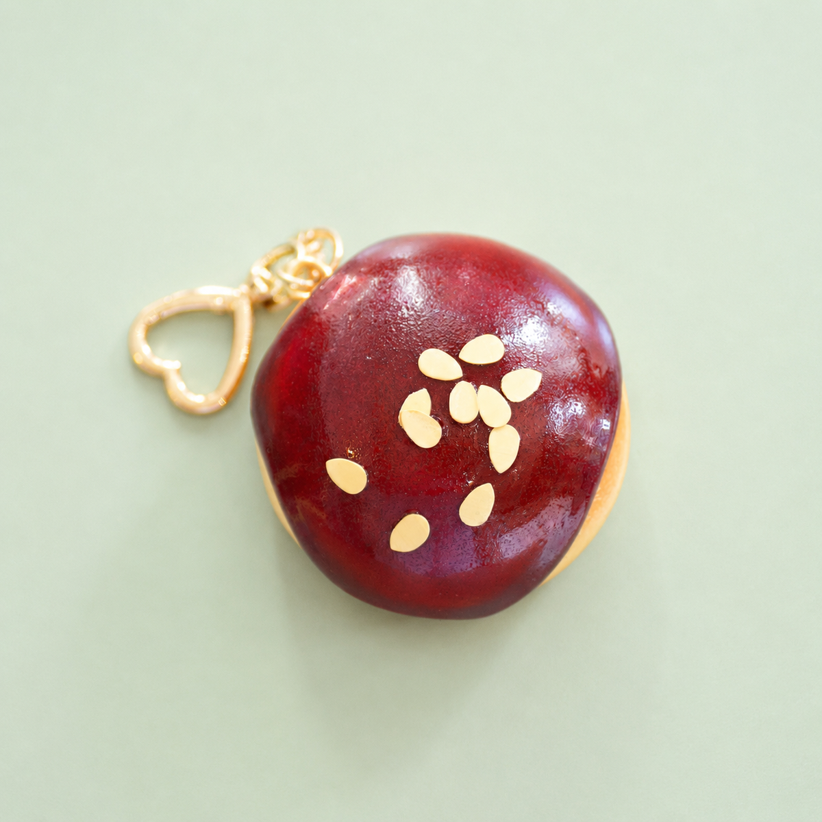Chocolate doughnut bag charm keyring with glossy dark chocolate icing, almond style sprinkles and gold heart shaped clip.