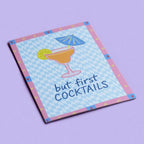 Playful But First Cocktails A5 print with blue checkerboard pattern and pink border, displayed on a soft lilac background.