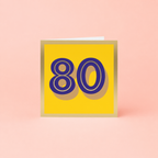 Colourful 80th birthday card with large purple number 80 on a bright yellow background with gold foil detailing and border.