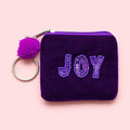 Purple velvet mini keyring purse with tonal purple beaded and sequin ‘JOY’ lettering, purple pom pom and silver tone keyring.
