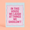 Cheerful pink and mint A5 art print reading “In This House We Laugh At Things We Shouldn’t” with a playful striped border.