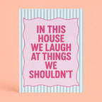 Cheerful pink and mint A5 art print reading “In This House We Laugh At Things We Shouldn’t” with a playful striped border.