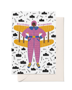 Birthday Wingwoman greeting card with illustrated woman in a pink flying suit, yellow plane wings and playful paper plane pattern.