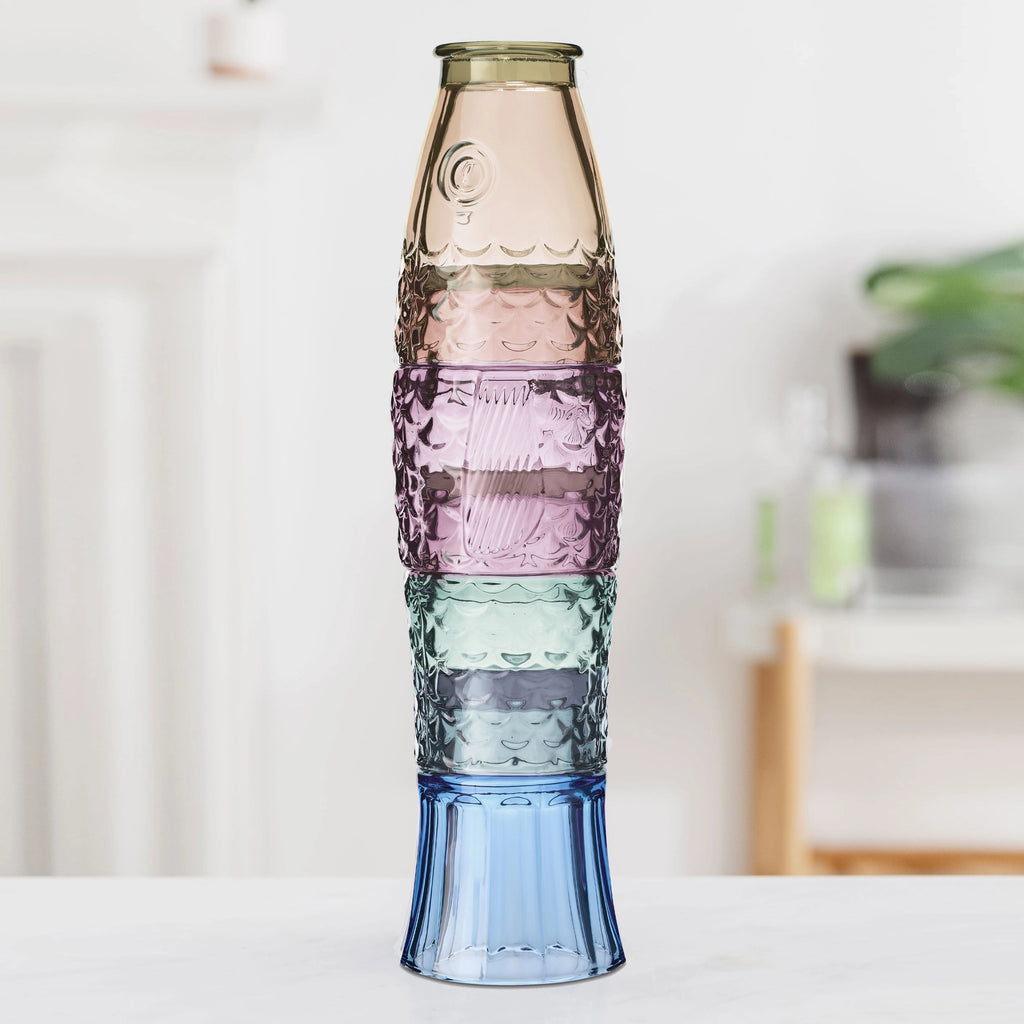Four multicoloured glass tumblers stacked together to create a tall fish shape.