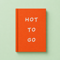 Bright orange A7 fabric hardback notebook with white Hot To Go lettering on a soft mint green background.