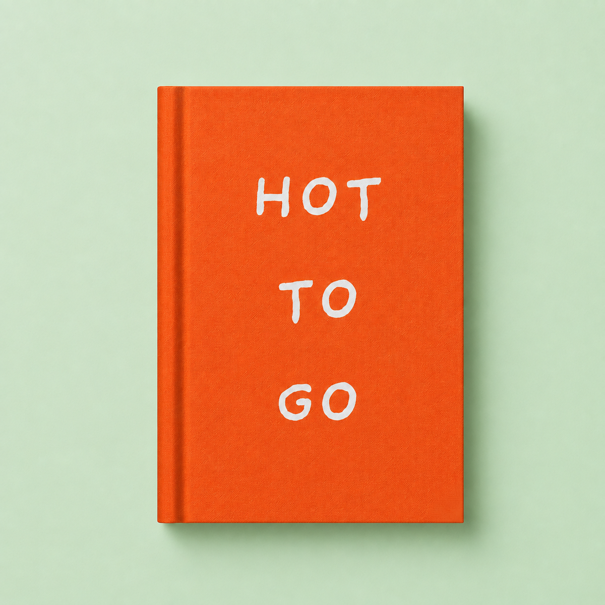 Bright orange A7 fabric hardback notebook with white Hot To Go lettering on a soft mint green background.