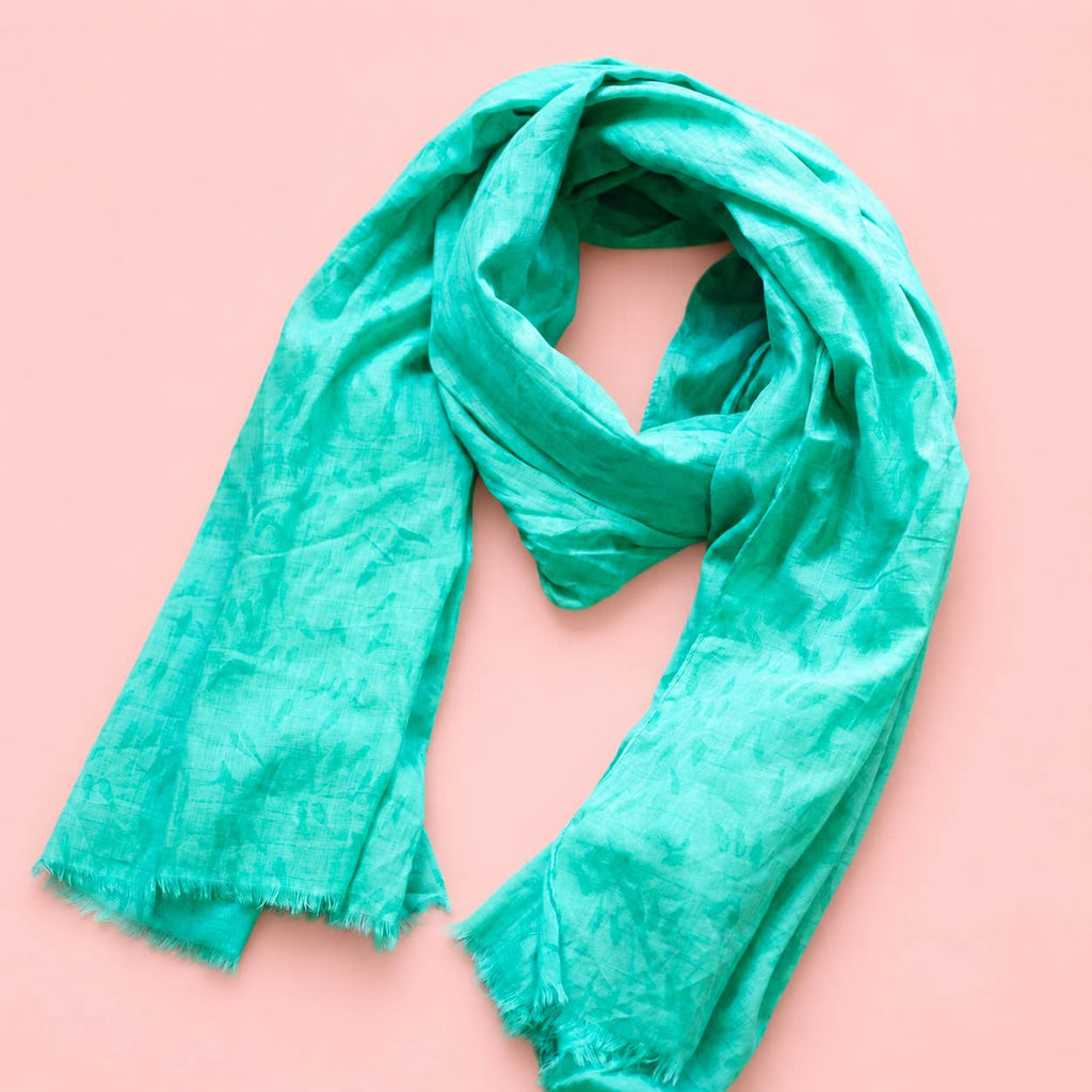 Beautiful aqua green cotton scarf loosely styled to show its subtle tonal bird pattern and softly frayed edges.