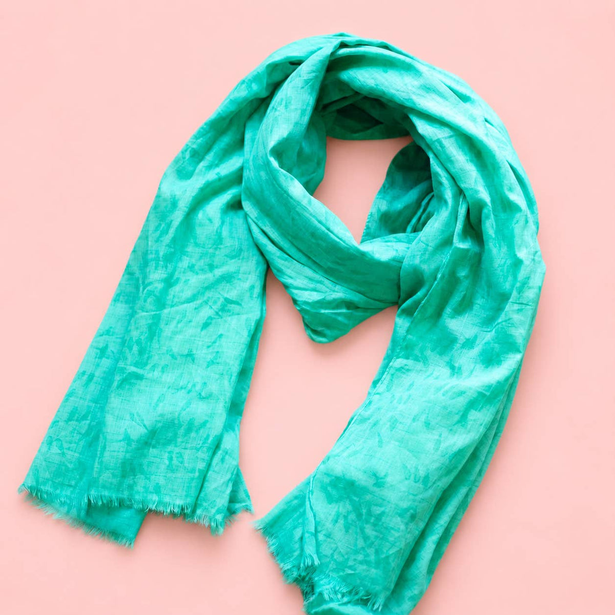Beautiful aqua green cotton scarf loosely styled to show its subtle tonal bird pattern and softly frayed edges.