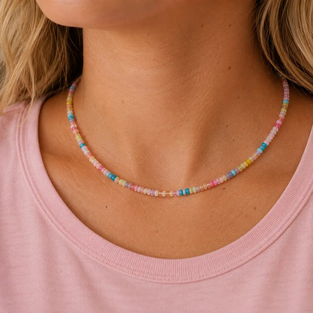 Woman wearing a colourful pastel natural stone bead necklace with blush pink, blue, yellow, lilac and aqua beads.