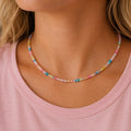 Woman wearing a colourful pastel natural stone bead necklace with blush pink, blue, yellow, lilac and aqua beads.