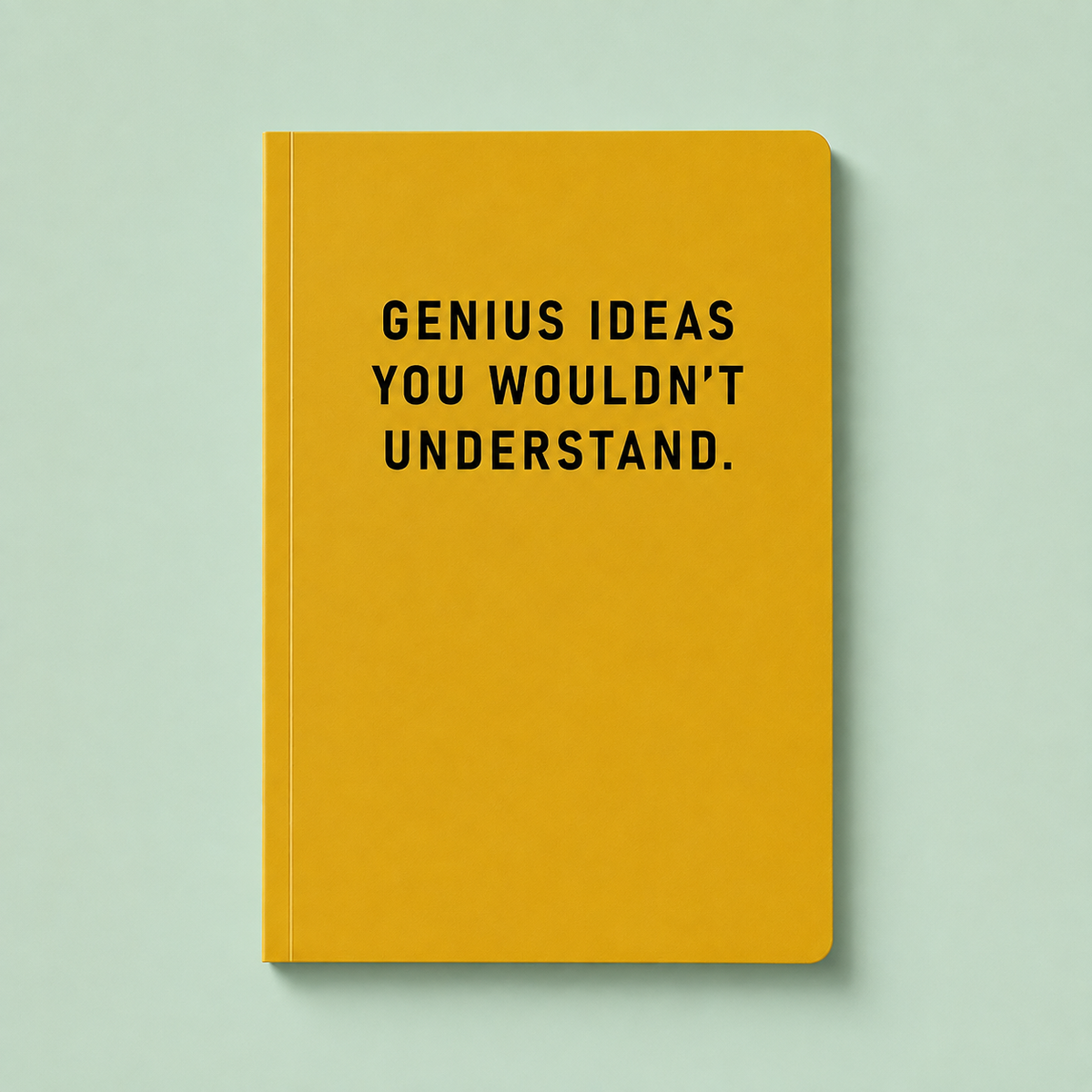 Bright yellow A5 paperback notebook with black Genius Ideas You Wouldn’t Understand text on a pale mint background.