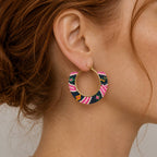 Pink multi geometric beaded hoop earring worn on the ear, showing the colourful glass bead pattern.