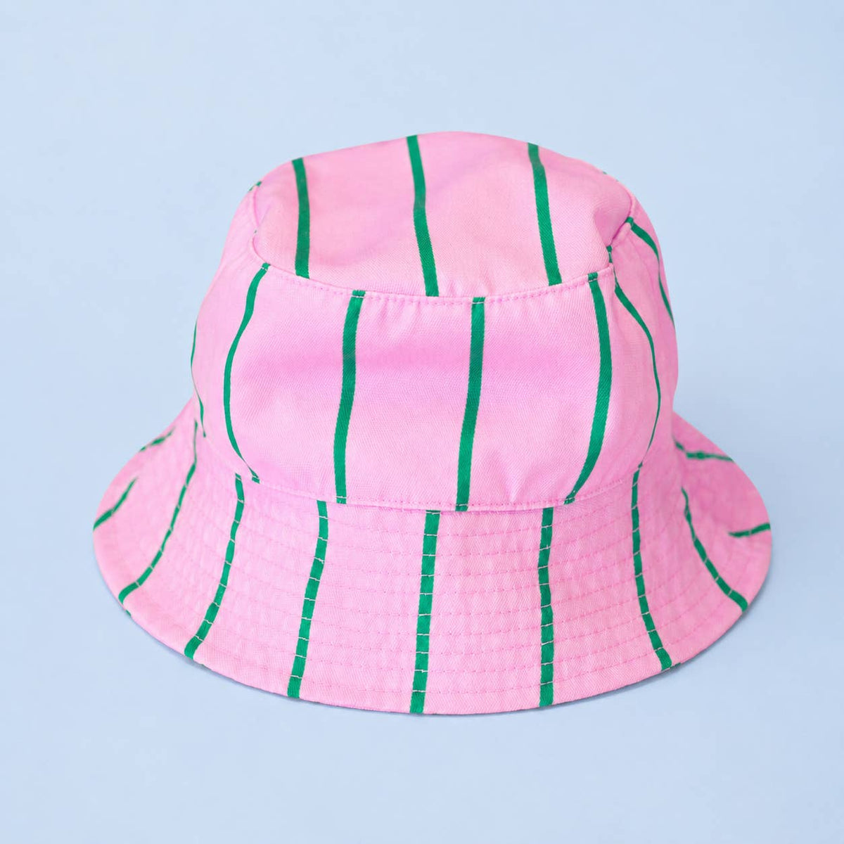 Pink bucket hat with vertical green stripes against a pale blue background.