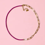 Two tone raspberry and gold plated stainless steel chain necklace on a soft pink background.