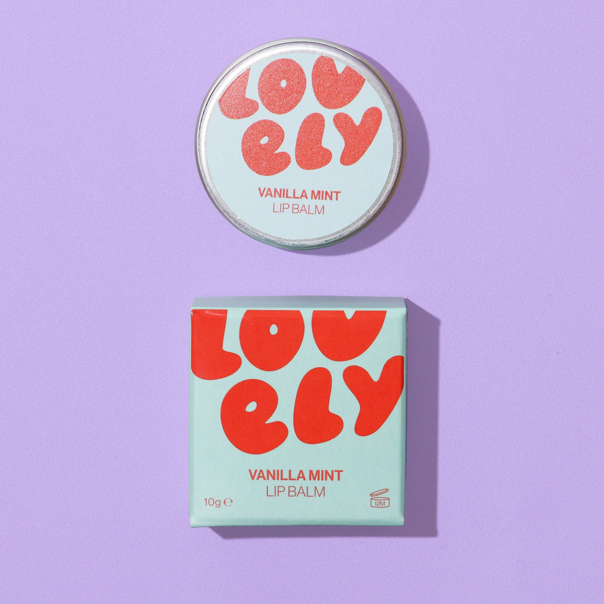 Vanilla Mint Lip Balm tin and colourful box photographed on a lilac background.