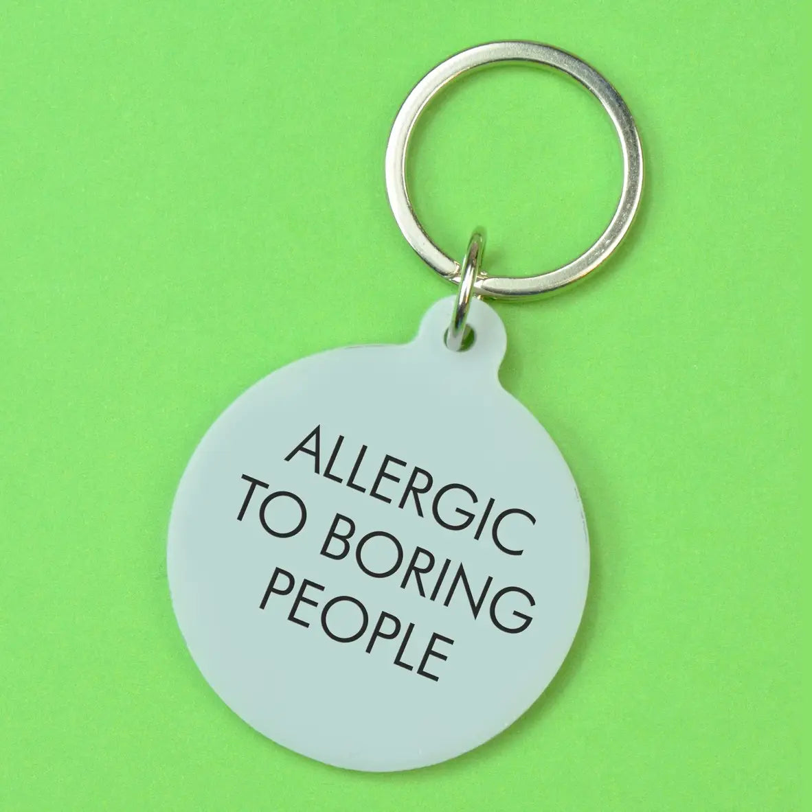 Silver round statement keyring with black Allergic to Boring People lettering and silver-tone metal keyring attachment.