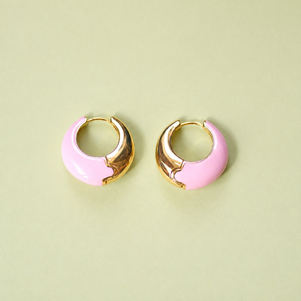 Pale pink enamel huggie hoop earrings with polished gold-tone detail.