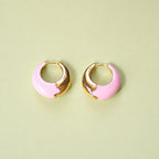 Pale pink enamel huggie hoop earrings with polished gold-tone detail.