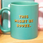 Green ceramic mug reading This Might Be Booze in gold and black lettering 