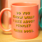Close up of pink ceramic mug reading Do You Know What I Like About People? Their Dogs in gold and black lettering.