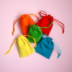 Colourful velvet drawstring mystery bags in orange, red, green, yellow and blue for Pocketful of Joy earrings.