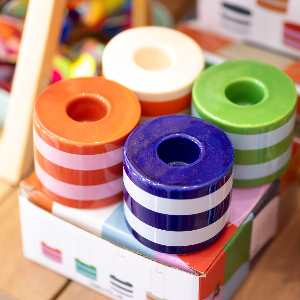 Set of four chunky striped ceramic candlestick holders in purple, green, orange, red, pink and cream with colourful presentation box.
