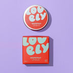Grapefruit Lip Balm 10g tin and colourful orange and blue box on a lilac background.