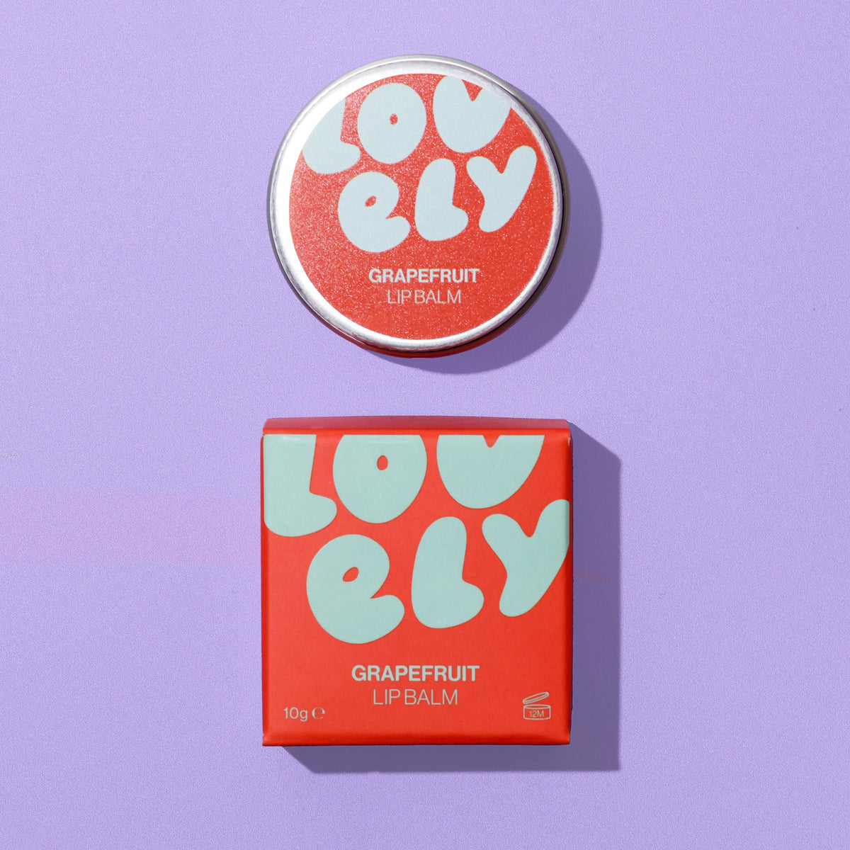 Grapefruit Lip Balm 10g tin and colourful orange and blue box on a lilac background.