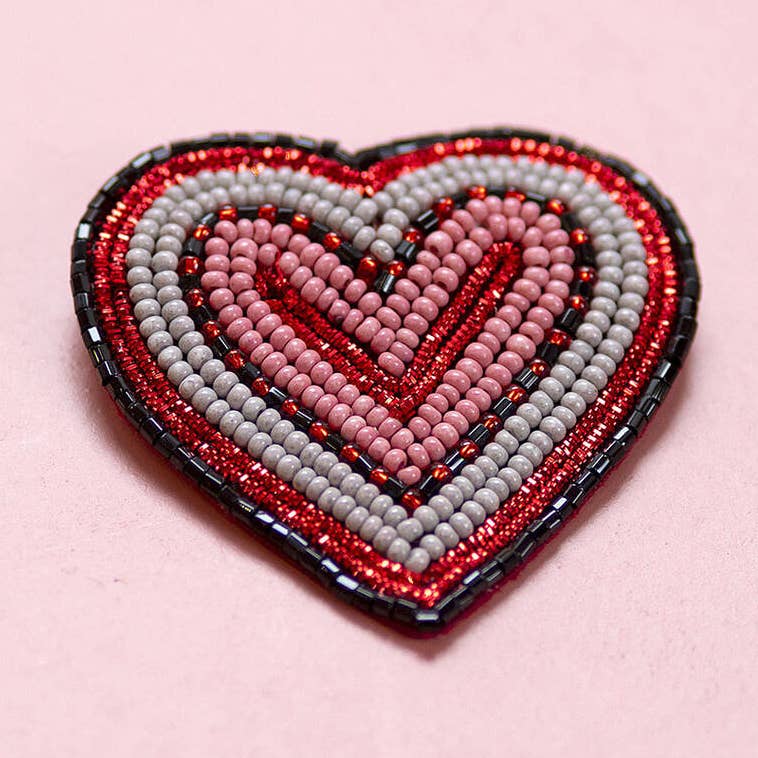 Red and pink heart shaped brooch with layered grey and black bead detailing.