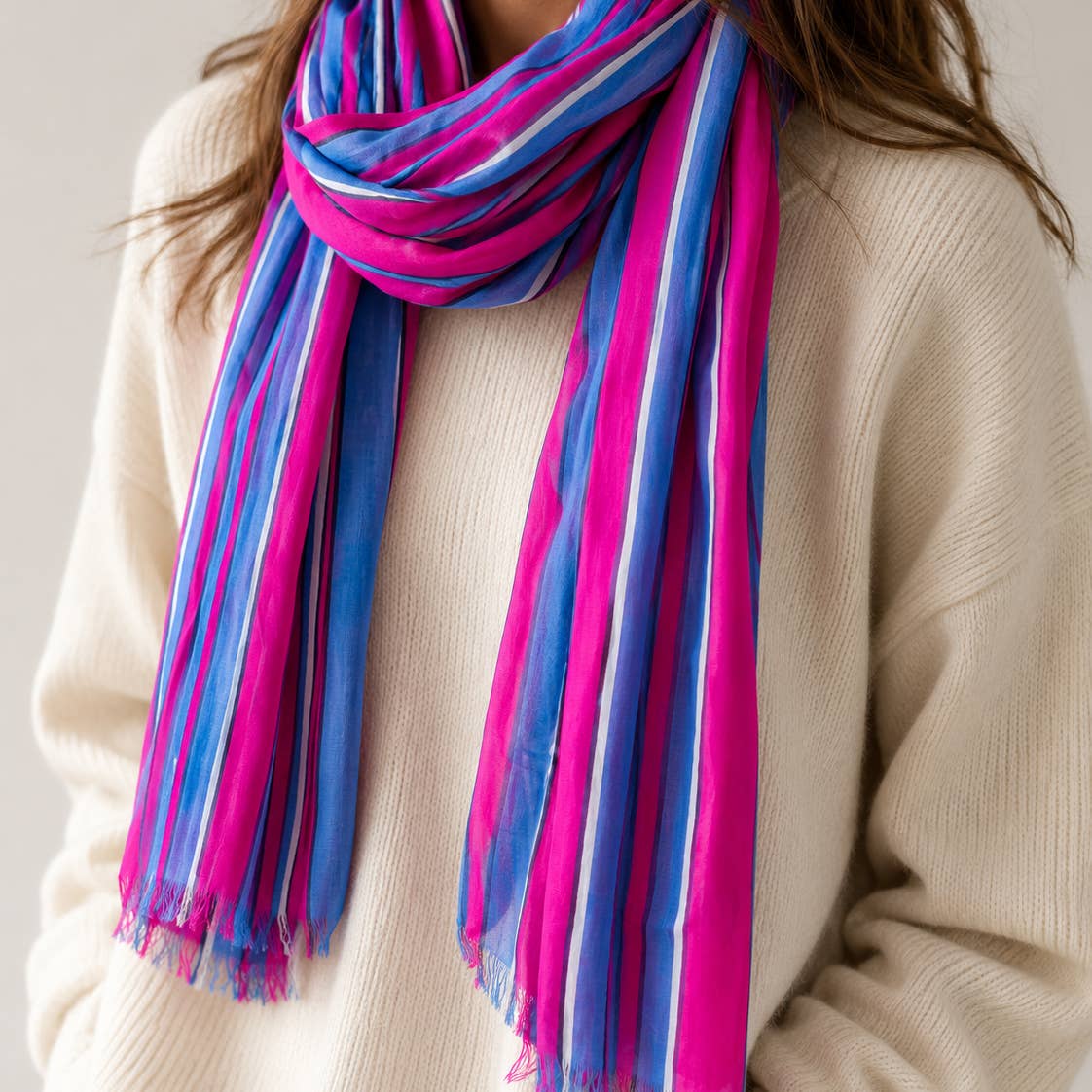 Fabulous pink and blue striped scarf bringing a bold burst of colour to a cosy cream jumper.